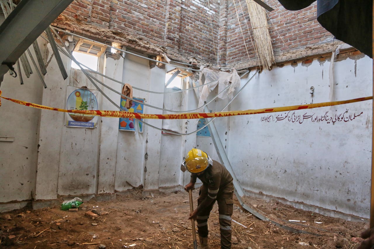 Rescuers working through the rubble of a collapsed school building in Peshawar, Pakistan.