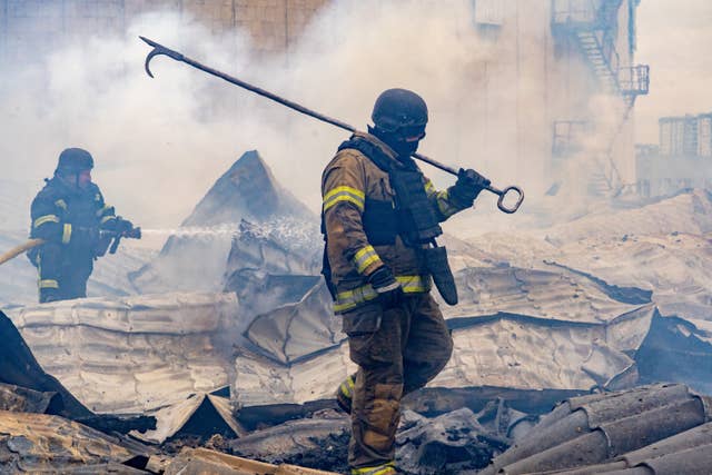 Rescuers working on the roof of a damaged building following Russia’s air attack in Kharkiv, Ukraine, on Friday